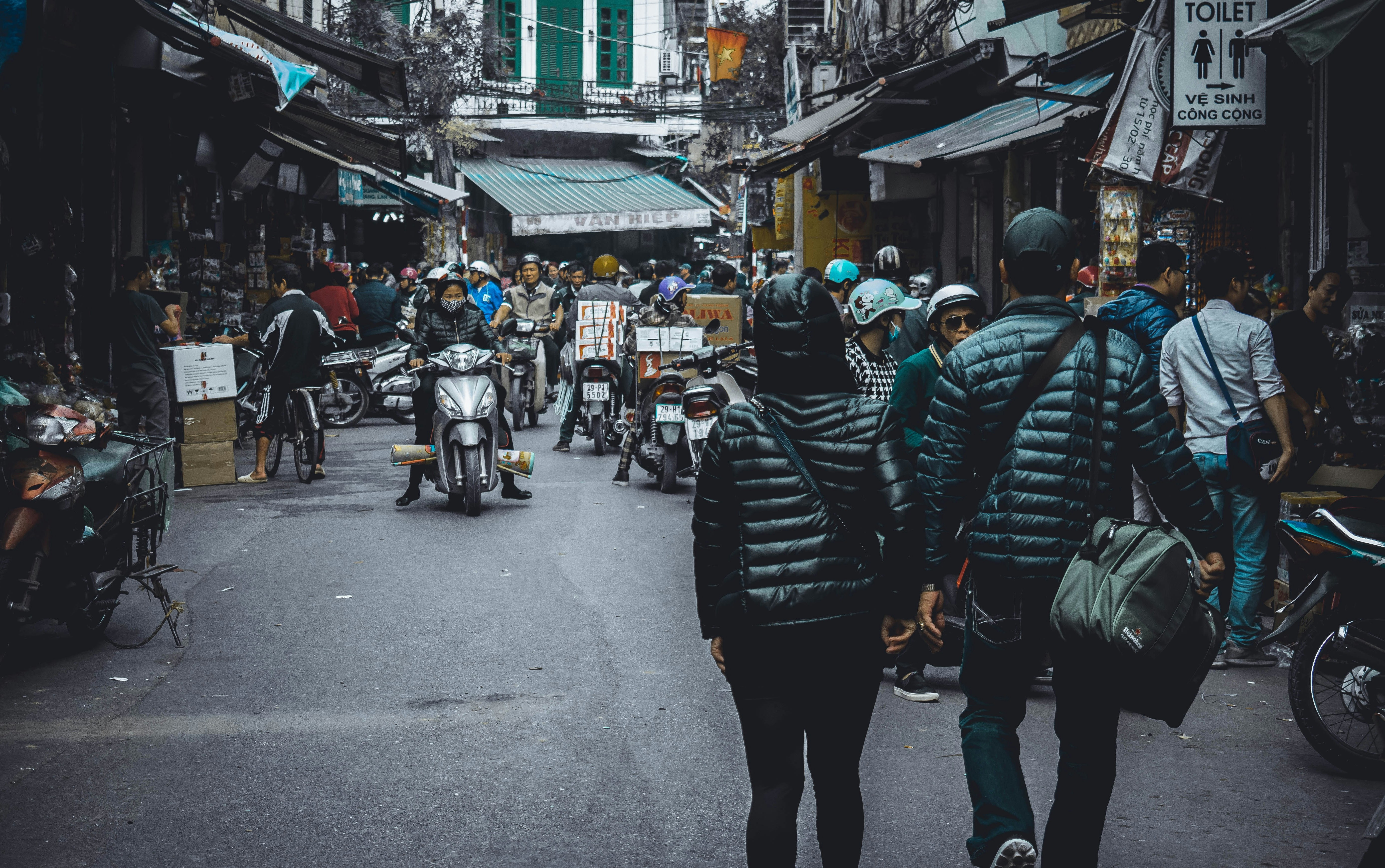 people walking on the street surrounded by concrete structures